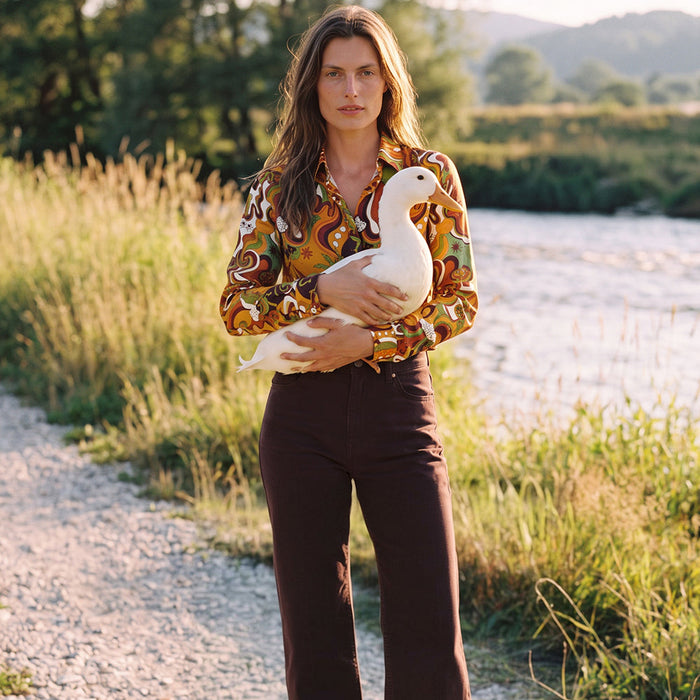Pantalon marron en denim porté avec un chemisier en soie